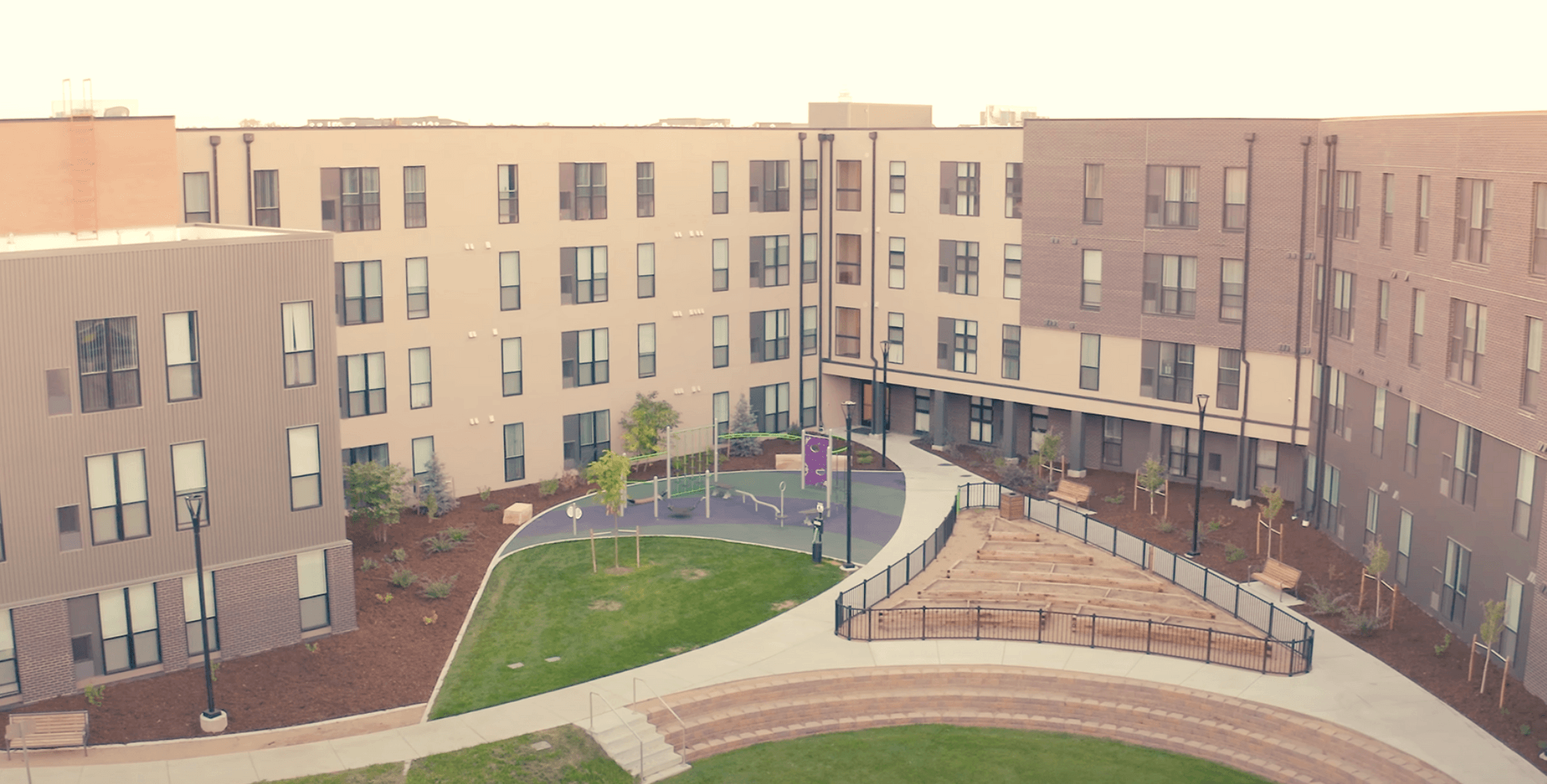 Aerial view of outdoor recreational space - playground, raised garden beds, open grassy lawn